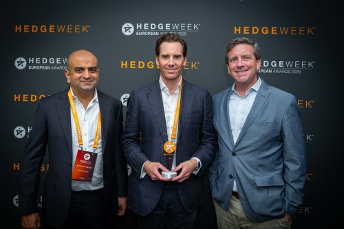 Background: black step and repeat with a white logo of a star and the words Hedgeweek European Awards 2025 Foreground three men holding a first place award.